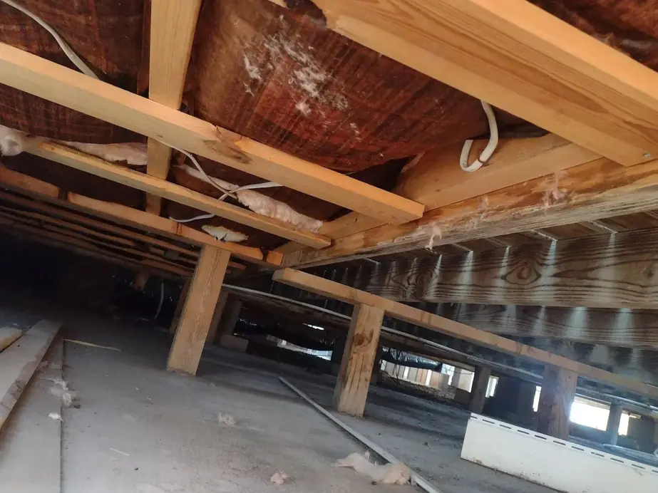 Floor joists, insulation and wood piers under a raised home
